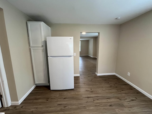 kitchen featuring dark wood-type flooring, white cabinets, and white refrigerator