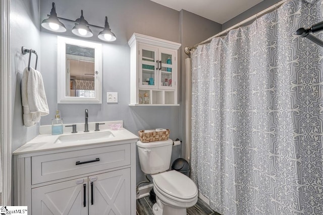 bathroom featuring a shower with curtain, vanity, and toilet