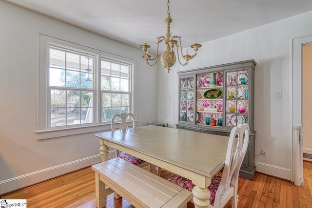 dining area with a notable chandelier and light hardwood / wood-style floors