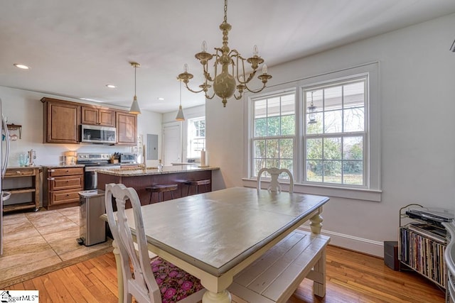 dining space with a notable chandelier and light hardwood / wood-style flooring