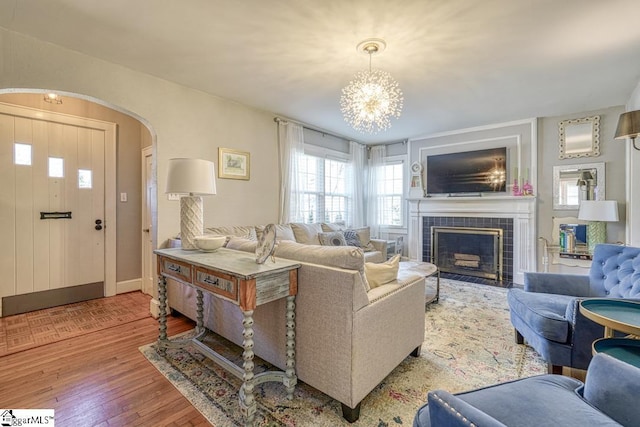 living room with hardwood / wood-style flooring, a fireplace, and an inviting chandelier