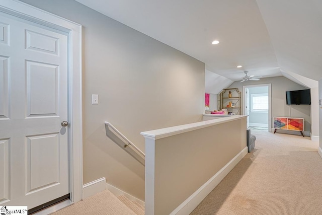 hallway with lofted ceiling and light carpet