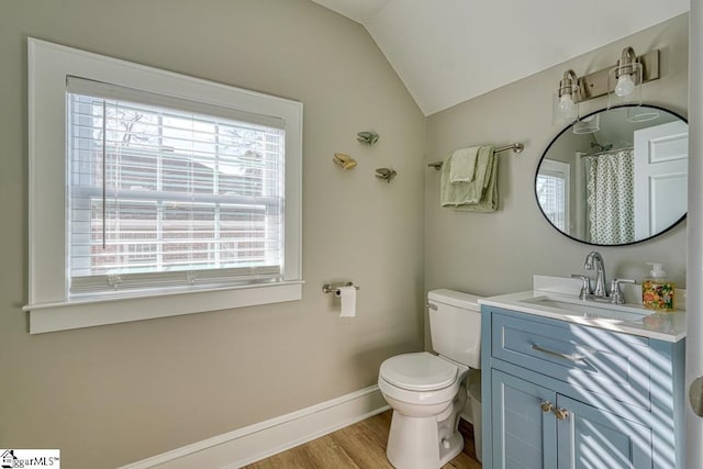 bathroom featuring lofted ceiling, vanity, hardwood / wood-style flooring, and toilet