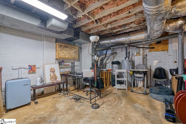 basement featuring water heater and brick wall