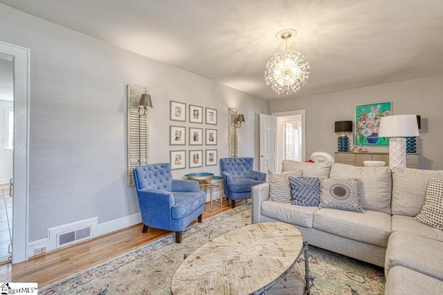 living room with an inviting chandelier and wood-type flooring