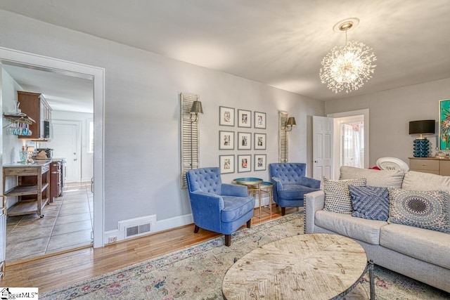 living room featuring an inviting chandelier and light hardwood / wood-style flooring