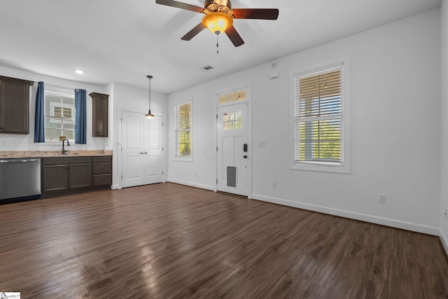 unfurnished living room with sink, dark hardwood / wood-style floors, a healthy amount of sunlight, and ceiling fan