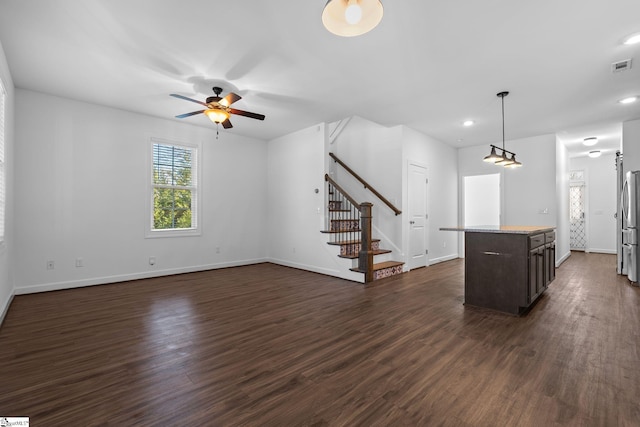 unfurnished living room with dark wood-type flooring and ceiling fan