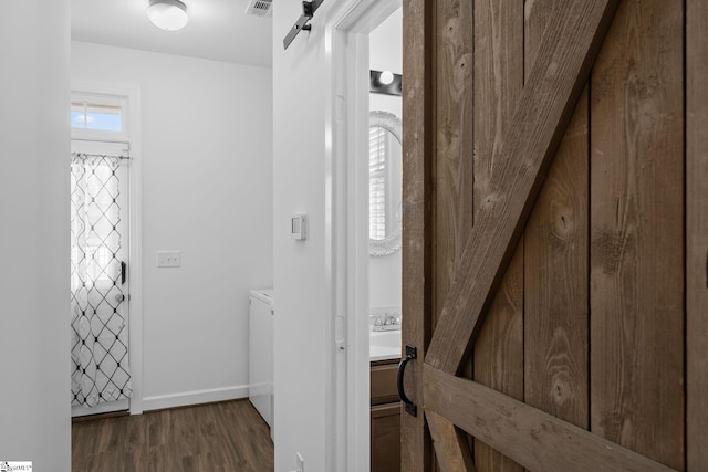 interior space with a barn door and dark hardwood / wood-style flooring