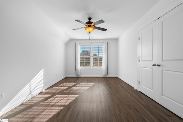 spare room with dark hardwood / wood-style flooring, lofted ceiling, and ceiling fan