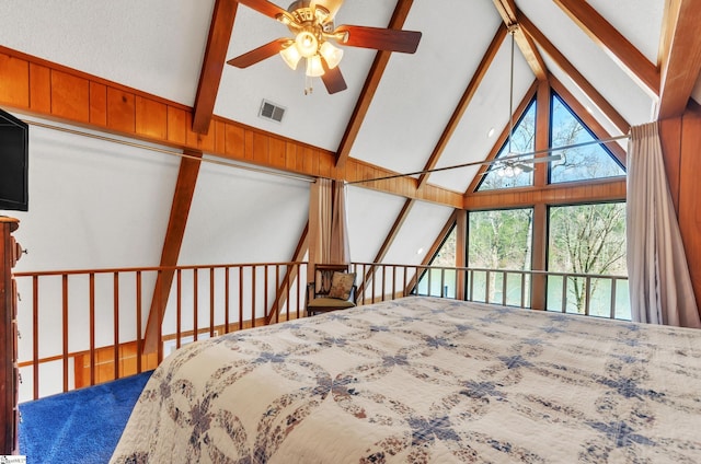 bedroom with high vaulted ceiling, wooden walls, and beam ceiling