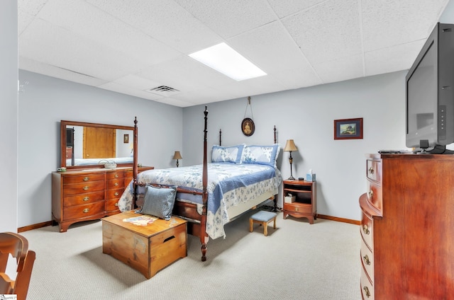 bedroom with light colored carpet and a drop ceiling