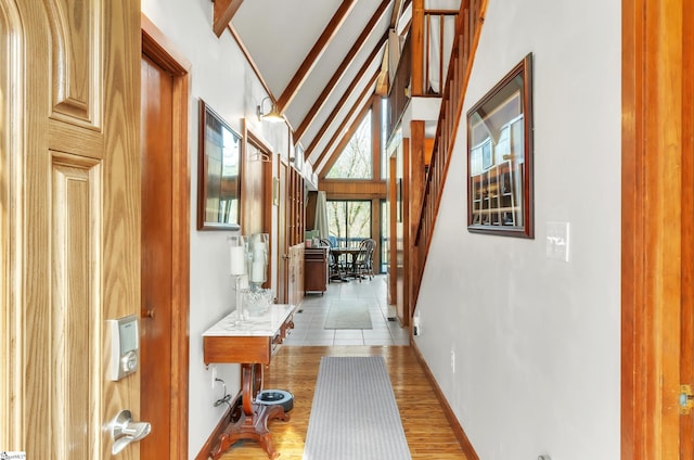 corridor featuring hardwood / wood-style floors, high vaulted ceiling, and beamed ceiling