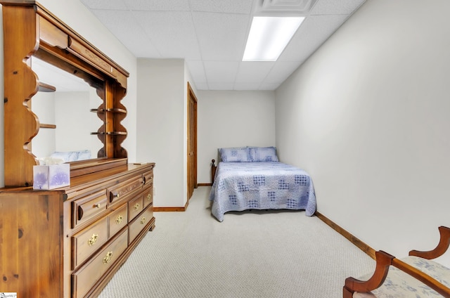 bedroom featuring light carpet and a paneled ceiling