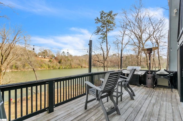 wooden terrace featuring a grill and a water view