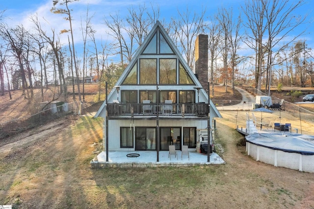 rear view of house with a covered pool and a patio