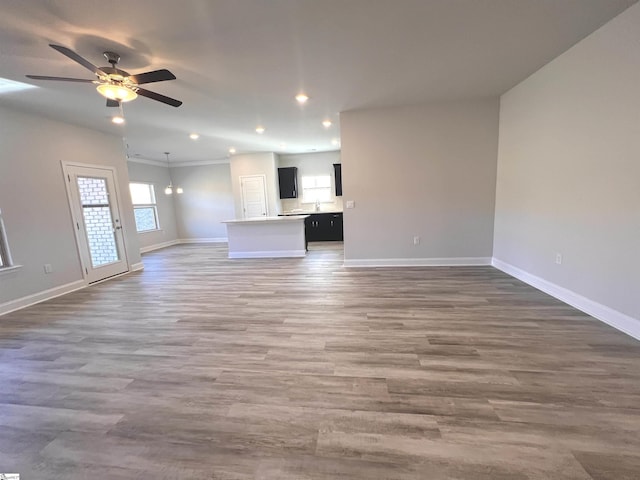 unfurnished living room featuring ceiling fan and dark hardwood / wood-style floors