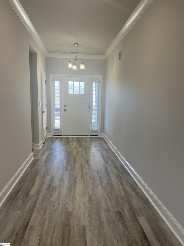 entryway featuring ornamental molding, dark hardwood / wood-style flooring, and a notable chandelier