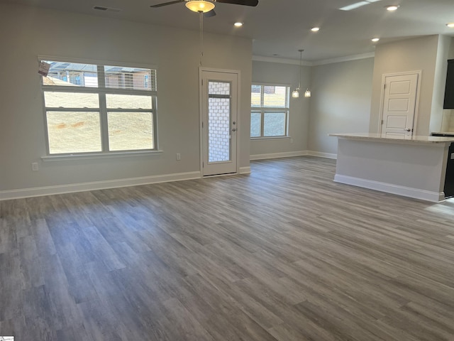 unfurnished living room featuring ornamental molding, dark wood-type flooring, and ceiling fan