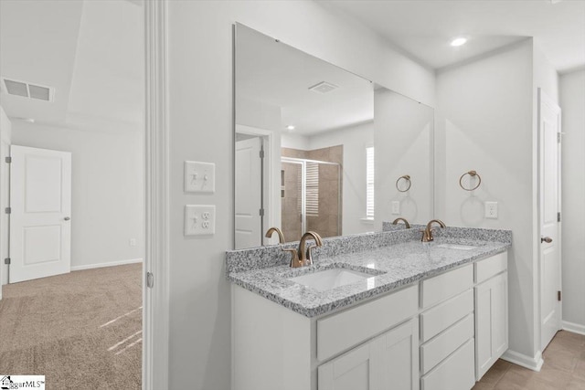 bathroom featuring a stall shower, visible vents, a sink, and double vanity