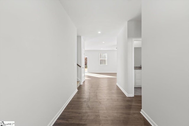 hall featuring recessed lighting, dark wood finished floors, and baseboards