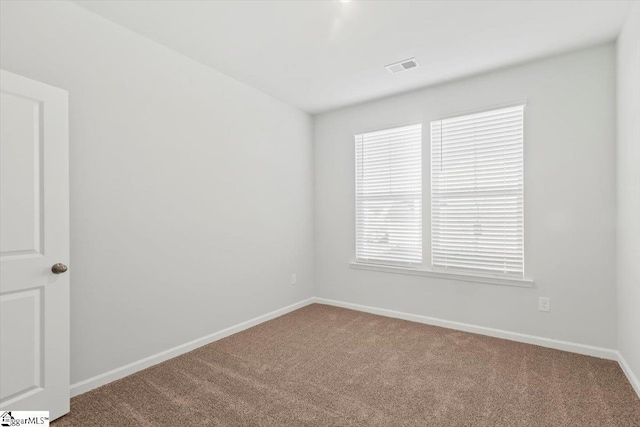 unfurnished room featuring baseboards, visible vents, and carpet flooring