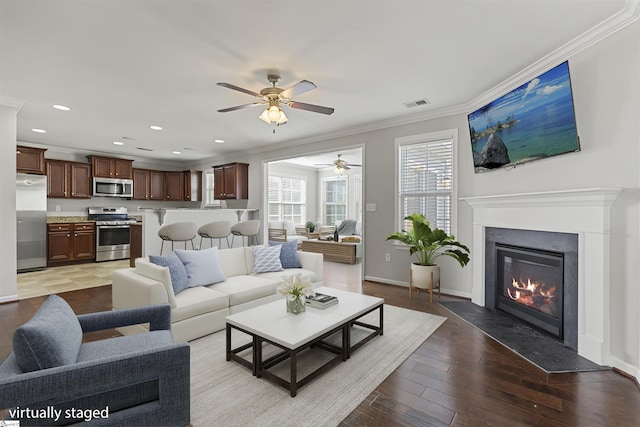 living room with ceiling fan, ornamental molding, and light hardwood / wood-style flooring