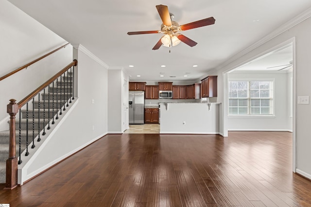 unfurnished living room with hardwood / wood-style flooring, ornamental molding, and ceiling fan