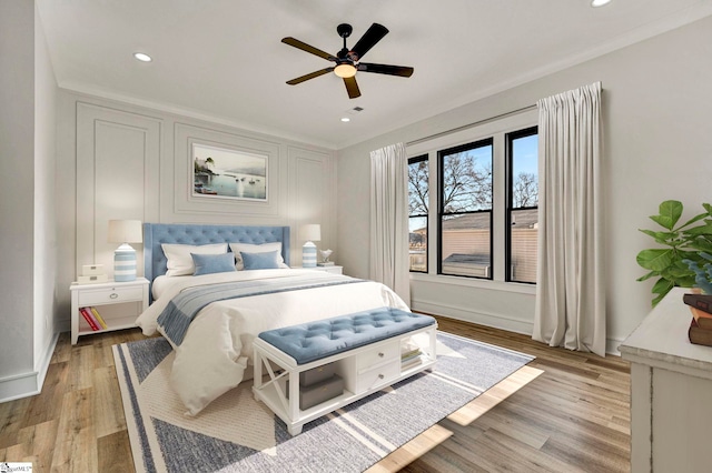 bedroom featuring ceiling fan, ornamental molding, and light hardwood / wood-style flooring