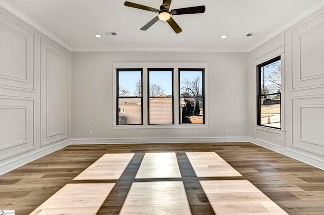 spare room with hardwood / wood-style floors, crown molding, and ceiling fan