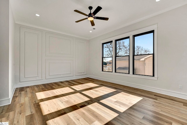 empty room with ceiling fan, ornamental molding, and light wood-type flooring