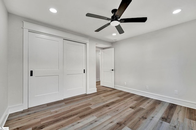 unfurnished bedroom with ceiling fan, a closet, and light hardwood / wood-style flooring