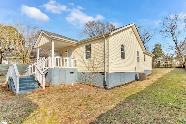 view of side of home with central AC and a yard