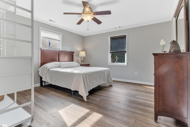 bedroom with crown molding, ceiling fan, and light hardwood / wood-style floors