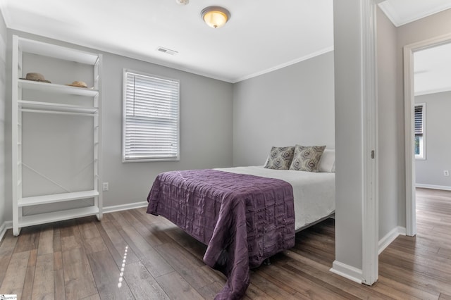 bedroom with ornamental molding and hardwood / wood-style floors