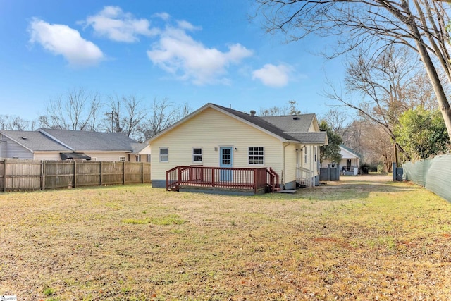 back of house featuring a lawn and a deck