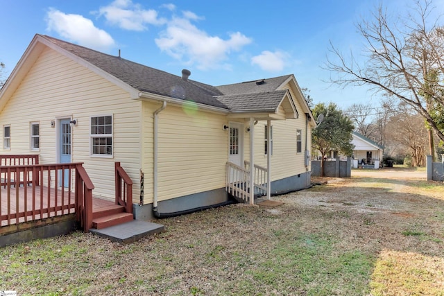 rear view of property featuring a wooden deck