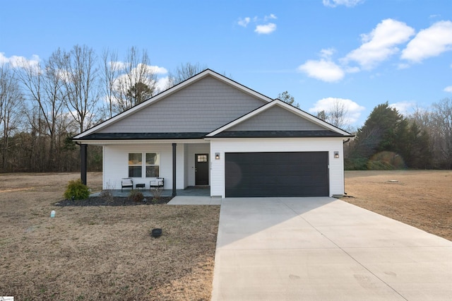 view of front of home featuring a porch, a garage, and a front lawn