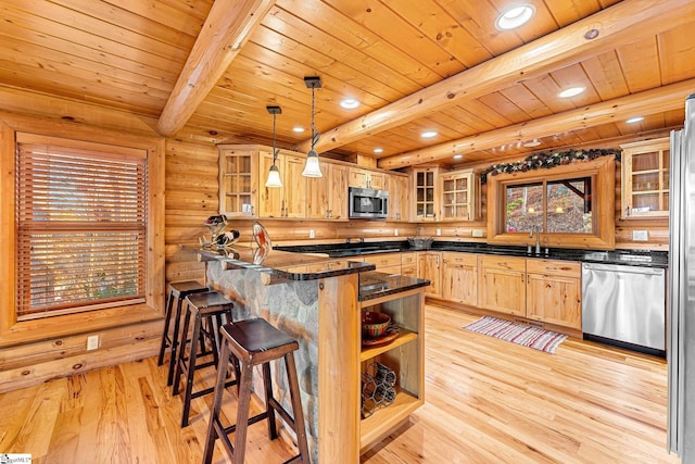 kitchen featuring hanging light fixtures, kitchen peninsula, stainless steel appliances, beam ceiling, and light hardwood / wood-style flooring