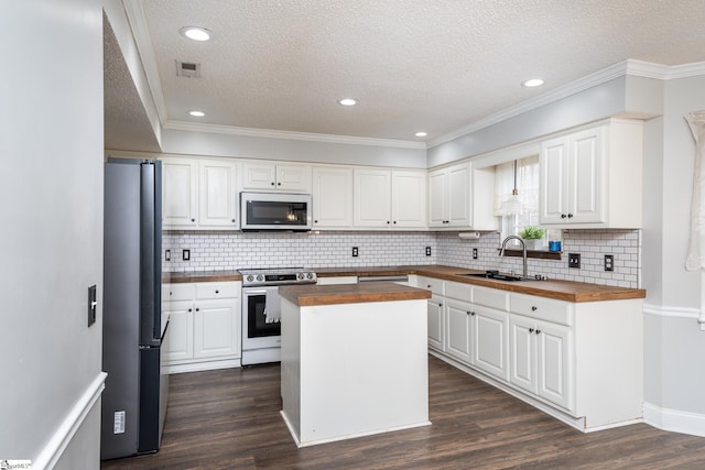 kitchen featuring white cabinetry, wood counters, stainless steel appliances, and sink