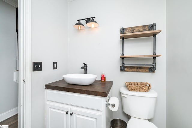 bathroom with vanity, toilet, and wood-type flooring