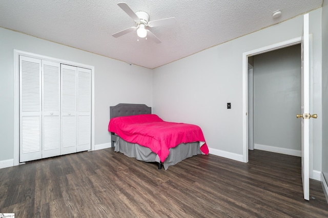 bedroom with dark hardwood / wood-style flooring, ceiling fan, a closet, and a textured ceiling