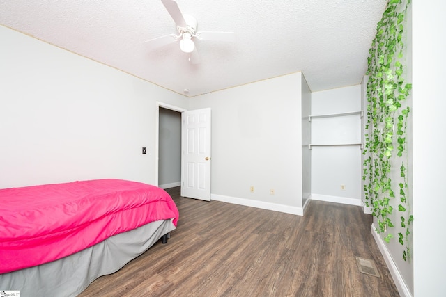 bedroom featuring ceiling fan, dark hardwood / wood-style flooring, and a textured ceiling