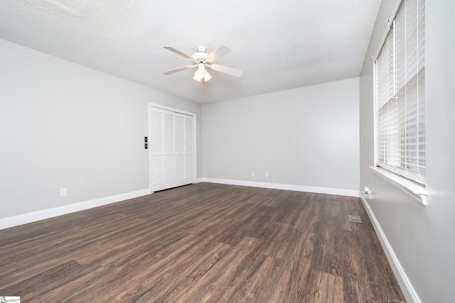 spare room featuring ceiling fan, dark hardwood / wood-style flooring, and a textured ceiling