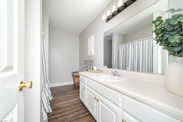 bathroom featuring vanity, hardwood / wood-style floors, and a textured ceiling