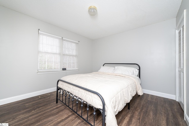 bedroom featuring dark hardwood / wood-style floors and a textured ceiling