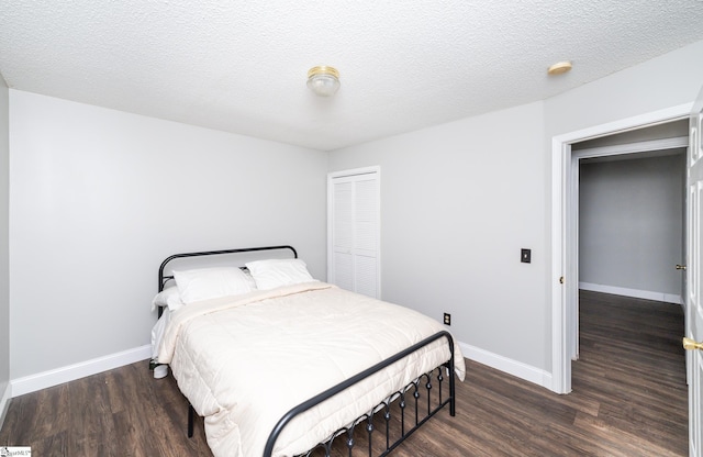 bedroom with dark hardwood / wood-style flooring, a closet, and a textured ceiling