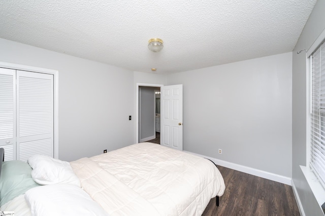 bedroom with a textured ceiling, dark hardwood / wood-style flooring, and a closet