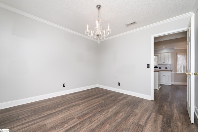 empty room featuring a notable chandelier, ornamental molding, dark hardwood / wood-style floors, and a textured ceiling