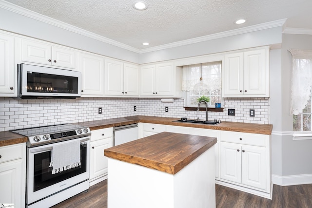 kitchen featuring a kitchen island, sink, white appliances, and wood counters